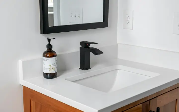 White vanity top with an undermount sink and black faucet