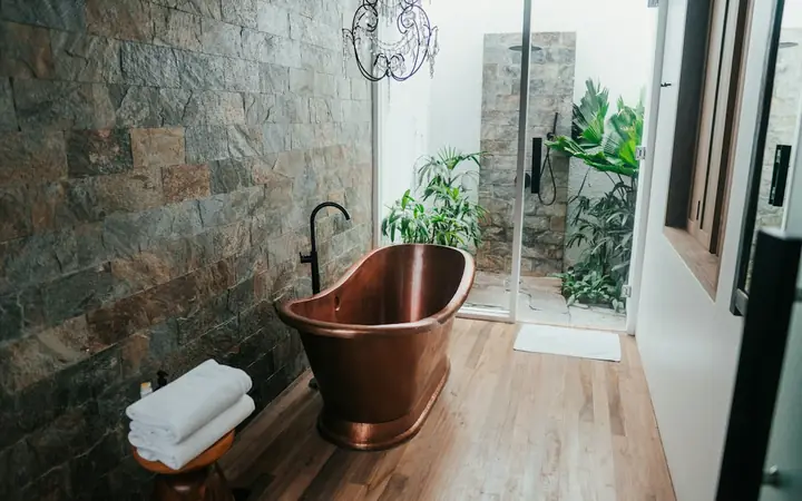 Luxury bathroom with a copper freestanding bathtub and slate wall