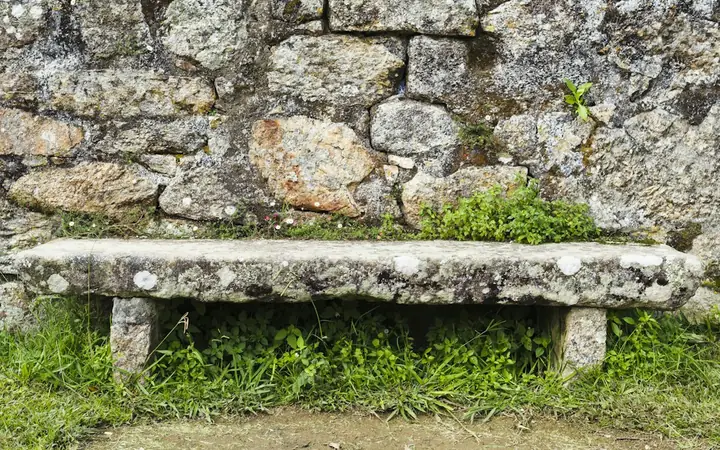 Stone bench set against an old garden stone wall