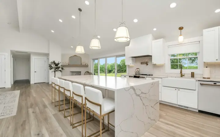 Kitchen island with a white marble waterfall countertop