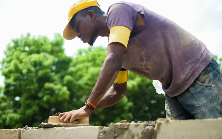 Mason laying bricks on a wall