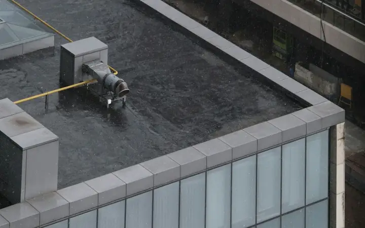 Dark membrane flat roof with a parapet edge on a city building