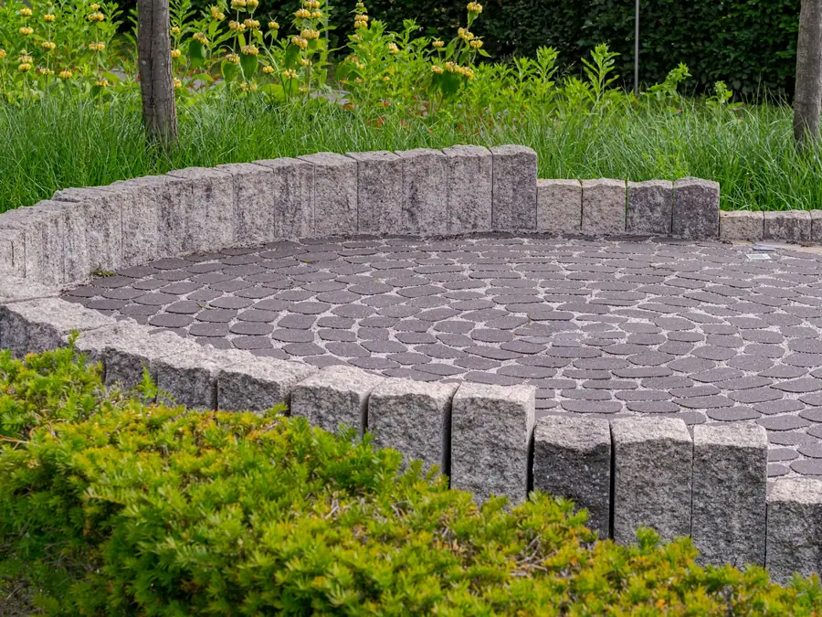 Circular paver patio edged with granite blocks